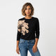 Blusa de punto con flor lateral